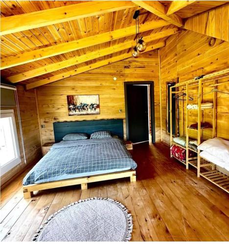 a bedroom with a bed in a wooden cabin at ByTemur Dağ Evi in Çamlıhemşin