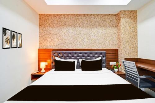 a bedroom with a large bed and a blue chair at Hotel GREEN LEAF in Hyderabad