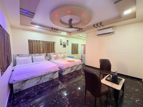 a bedroom with two beds and a table and chairs at Appa Hillside Nature Resort in Karjat