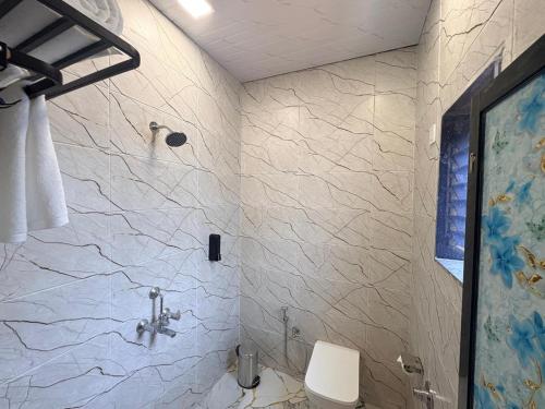 a bathroom with a shower and a toilet at Appa Hillside Nature Resort in Karjat