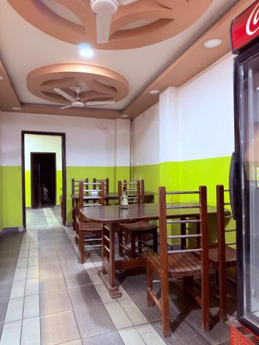 a dining room with a table and wooden chairs at Abc HOTEL & LODGE in Biratnagar