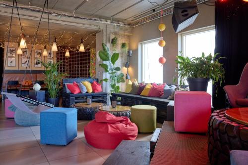 a living room with colorful furniture and plants at Midgard Base Camp in Hvolsvöllur