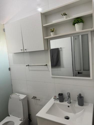 a bathroom with a sink and a mirror and a toilet at Casa Amélia in Cidade Velha