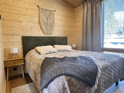 a bedroom with a bed and a wooden wall at Peaceful Cabin with Hot Tub and Nature Views, Villa Lakeside Ruka in Ruka