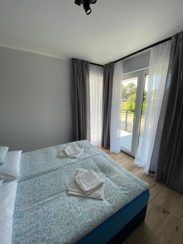 a bedroom with a bed with two napkins on it at Baltic Stay in Władysławowo