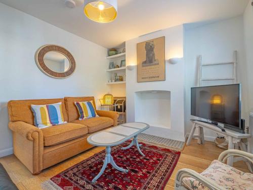 a living room with a couch and a tv at Seagrass Cottage - 3bed, Private Parking, Secluded Garden, Minutes from Whitstable town in Whitstable