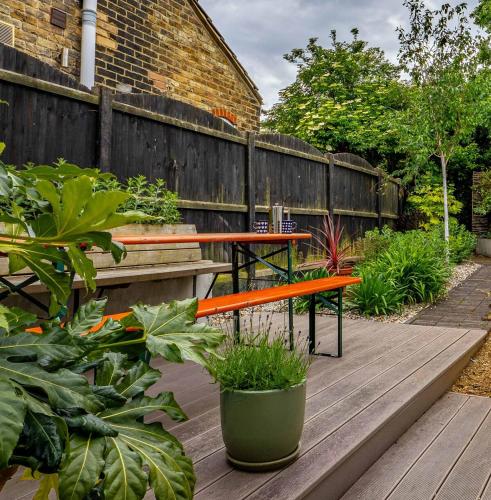 a patio with a bench and a table and plants at Seagrass Cottage - 3bed, Private Parking, Secluded Garden, Minutes from Whitstable town in Whitstable