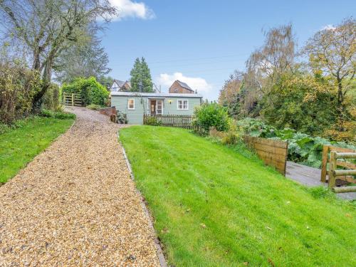 a house with a gravel driveway in front of a yard at The Shepherds Rest - Uk45532 in Buildwas