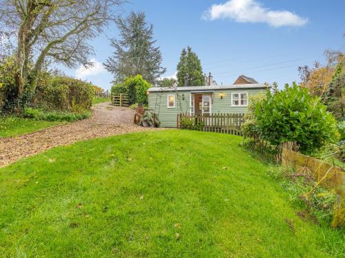 a small green house in the middle of a yard at The Shepherds Rest - Uk45532 in Buildwas