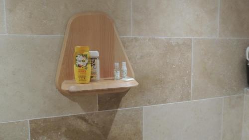 a bathroom with a shelf with products on it at Villa Studio Cosy Hauteur Vallauris L'Atelier in Vallauris