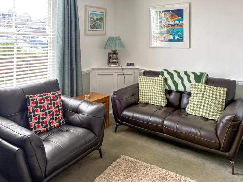 a living room with two leather chairs and a couch at Old Town Cottage in Sidmouth