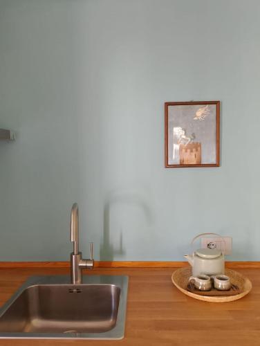 a kitchen counter with a sink and a picture on the wall at Appartamento LaLieve - casaDELRESTO in Gaiola