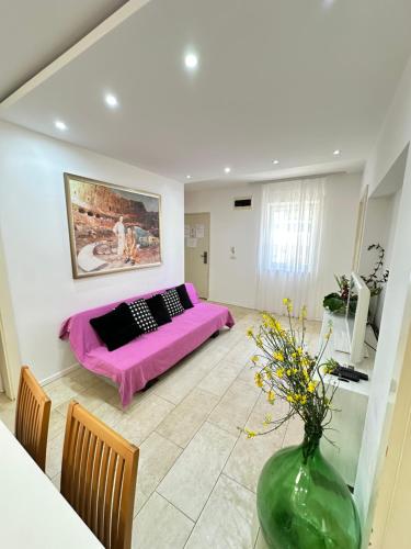 a bedroom with a purple bed and a vase with flowers at Apartments Karmen Maria in Novigrad Istria