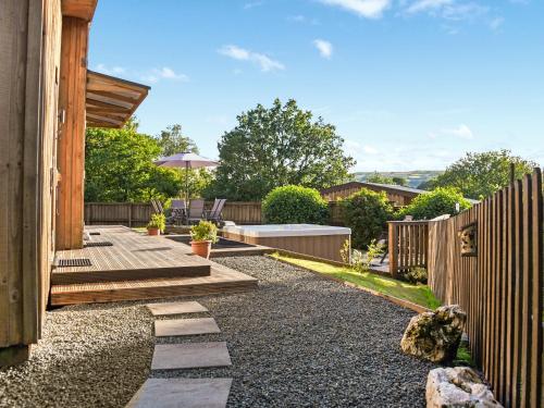 a garden with a wooden fence and a patio at Ash Lodge At Lon Lodges in Nantmel