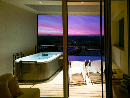 a jacuzzi tub on a balcony with a view at Stock & Stein Lodges in Bad Gleichenberg
