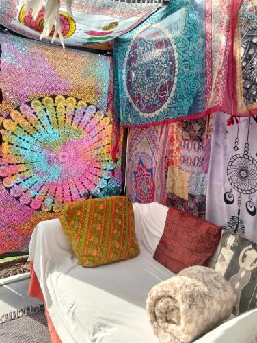 a bed in front of a wall with colorful blankets and pillows at The Hidden Corner in Sedgefield