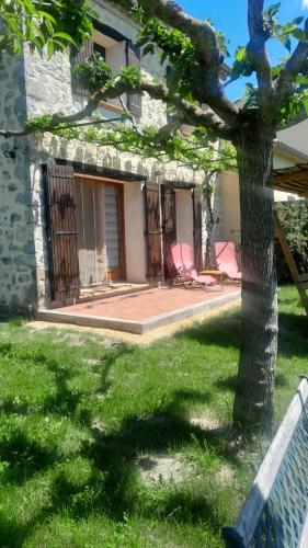a house with two chairs in a yard at maisonnette le cabanon in Sainte-Jalle