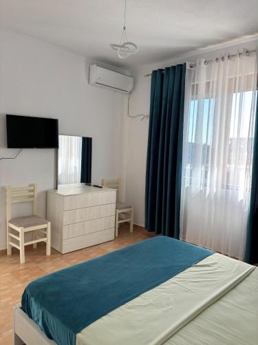 sypialnia z łóżkiem, komodą i telewizorem w obiekcie Villa 7 w Durrës