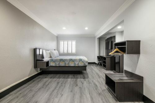 a bedroom with a bed and a desk in a room at Motel 6-Anaheim, CA - Convention Center in Anaheim