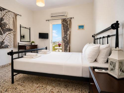 ein Schlafzimmer mit einem großen Bett und einem Fenster in der Unterkunft Koukounari Rooms in Skala
