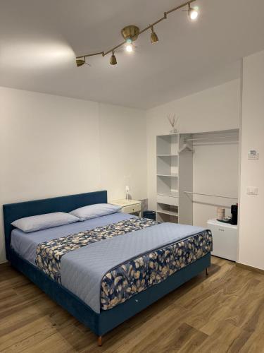 a bedroom with a blue bed and a white wall at B&B Aura in Pontecagnano