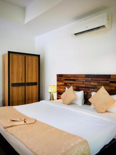 a bedroom with two beds and a brick wall at Nature Luxe Sigiriya in Sigiriya