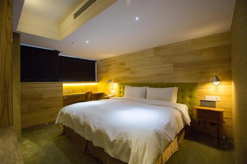 a bedroom with a large bed and a wooden wall at Inhouse Hotel Taichung in Taichung