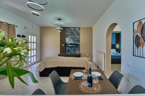 a living room with a bed and a table and chairs at Villa Escapes By The Beach in Sidari