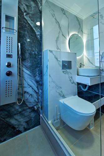 a bathroom with a blue toilet and a shower at Villa Escapes By The Beach in Sidari