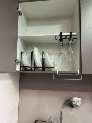 a bathroom mirror with plates and glasses on a shelf at Sunset Retreat Sensory Residence in Kampung Dengkil