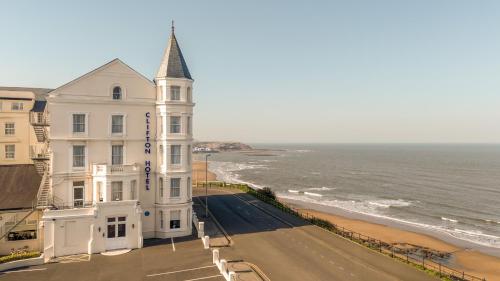 a large white building next to the ocean at Clifton Hotel in Scarborough