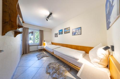 a room with two beds and a window at Alpenblick-Apartment mit Pool & Sauna in St. Moritz