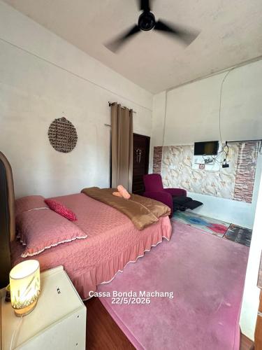 a bedroom with a bed and a ceiling fan at Cassa Bonda Standard Double Room in Macang