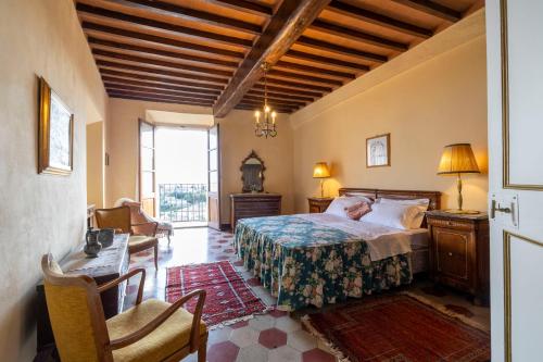 a bedroom with a bed and a chair and a window at castello di sovicille in Sovicille