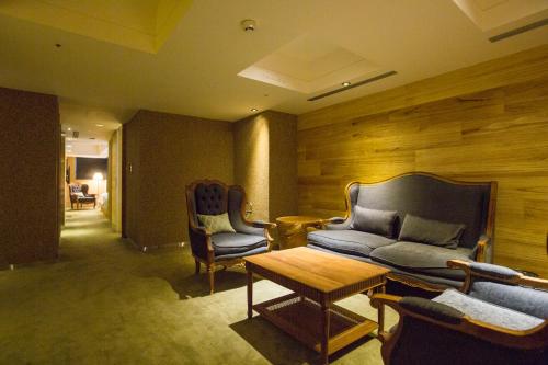 a living room with a couch and chairs and a table at Inhouse Hotel Taichung in Taichung