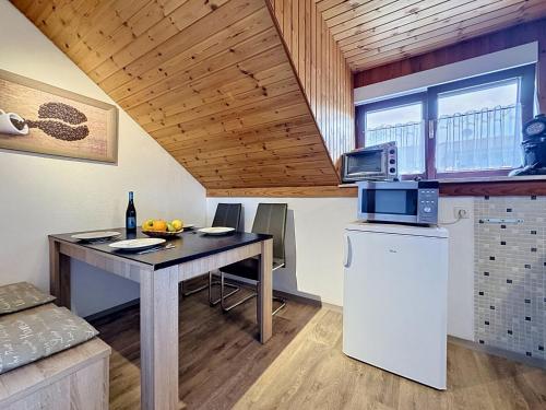 a kitchen and dining room with a table and a microwave at Apartment Sirch-3 by Interhome in Diedorf