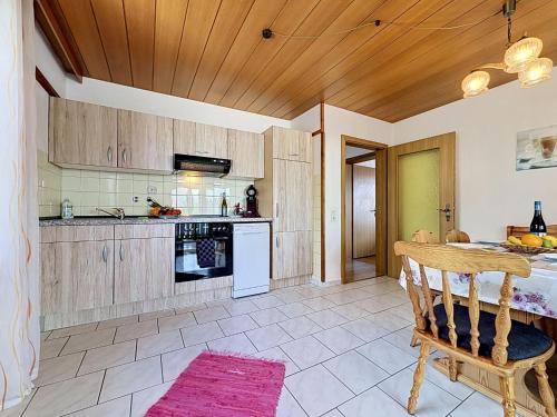 a kitchen with wooden cabinets and a table at Apartment Sirch-4 by Interhome in Diedorf