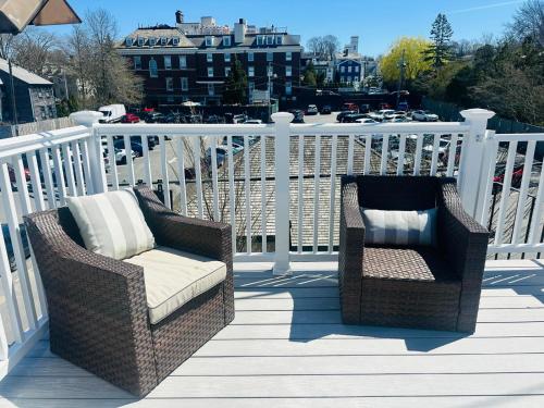 two wicker chairs sitting on a wooden deck at Downtown Suite #4 - Wharf View in Newport