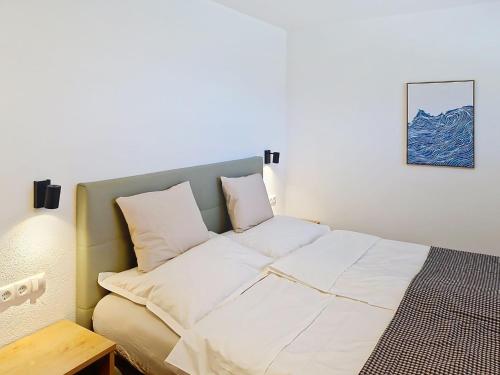 a bed with white sheets and pillows in a room at Apartment A3 by Interhome in Kematen in Tirol
