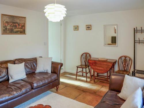 a living room with a couch and a table at Pam's Cottage in Cheltenham