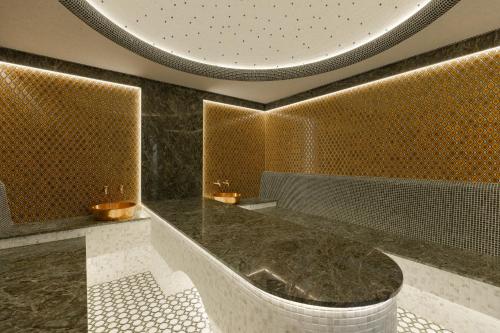 a bathroom with a tub in a room with gold at Mustafa Hotel in Samarkand