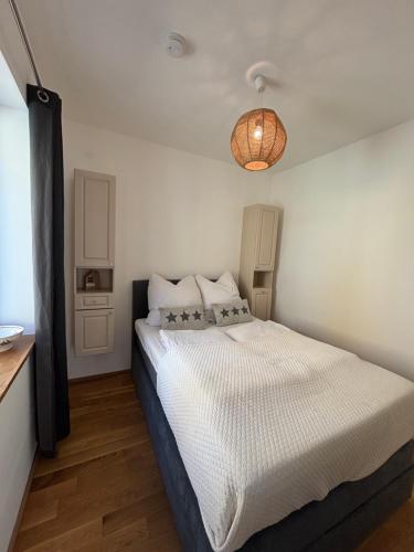 a bedroom with a large white bed with a light at MainApartment 1A in Margetshöchheim