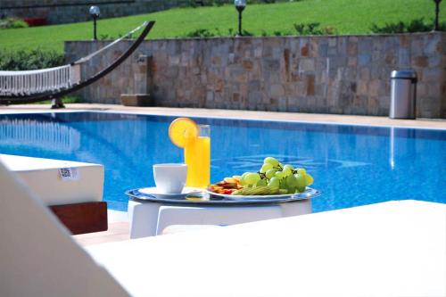 a tray of fruit on a table next to a pool at Любомировата къща in Sredni Kolibi