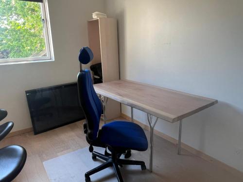 an office with a desk and a blue chair at Thistedvej 40 in Nørresundby