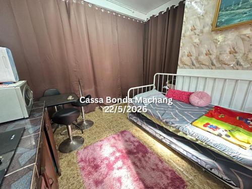 a bedroom with a bed with a rug and a desk at Cassa Bonda Single Studio in Kampong Bakat