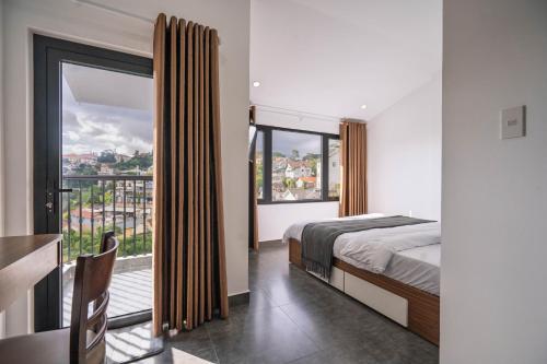 a bedroom with a bed and a large window at Mộc in Ấp Ða Lợi