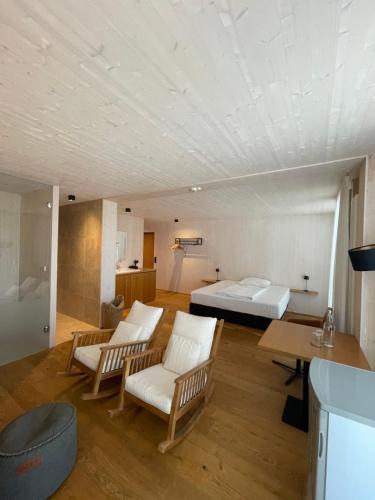 a room with a bed and chairs and a table at 2ND HOME HOTEL - Ihr 4 Sterne Hotel in Nördlingen als zweites Zuhause in Nördlingen