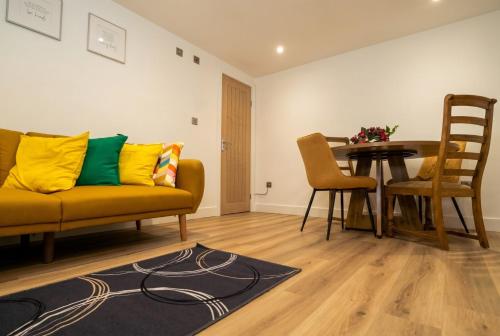 a living room with a couch and a table at Garden Studio in Hove, Parking & Hot Tub in Brighton & Hove