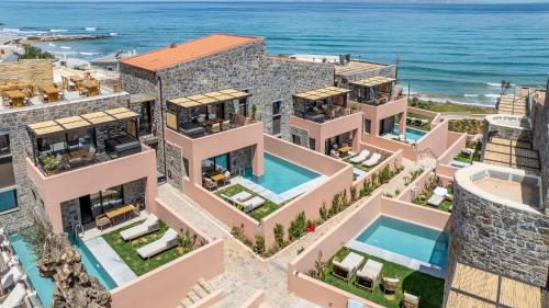 an aerial view of a building with the ocean in the background at Volta Seaside Boutique Hotel in Kokkini Khanion