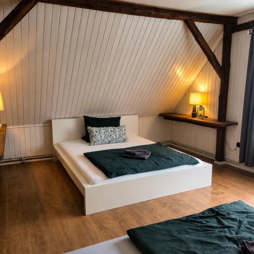 a bedroom with a white bed in a attic at LandOase Buchhorst in Balge